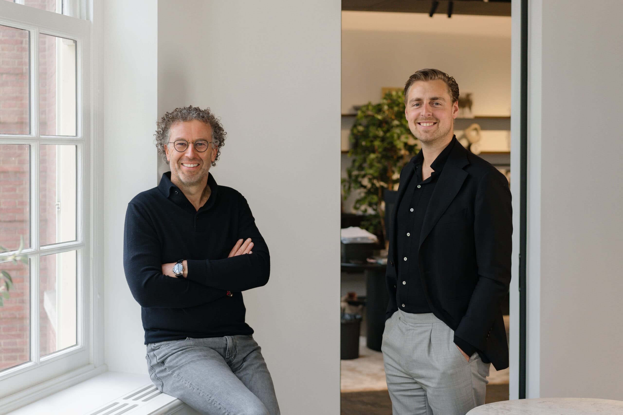 Paul en Boudewijn staand naast een raam